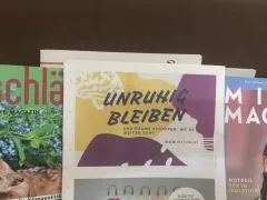 Zeitschriftenstapel mit feministischen Themen, zentral: "Unruhig bleiben".