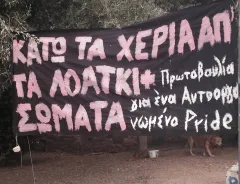 Schwarzes Banner mit rosa und weißem Text, schildert eine Botschaft in einem Garten.