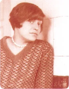 Fotografie einer Person mit Kurzhaarschnitt und Pullover, leicht zur Seite blickend.