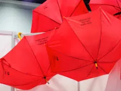 Rote Regenschirme hängen an einer Decke.