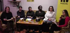 Diskussionsrunde mit sechs Frauen auf Sofas, Mikrofon und Tisch mit Getränken.
