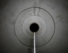 Blick in einen beleuchteten Betontunnel mit konzentrischen Kreisen.